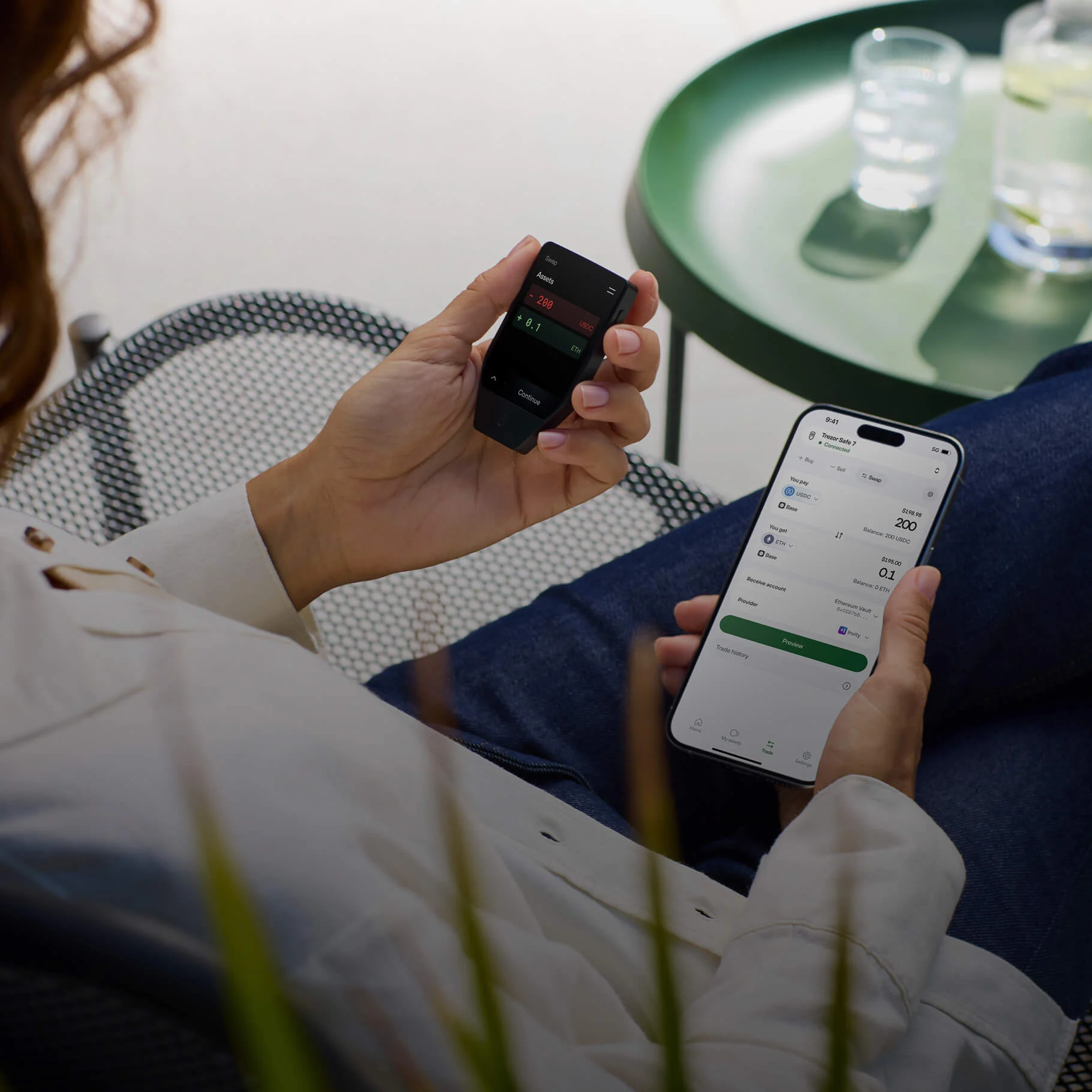 Person using a Trezor Safe 7 hardware wallet with its color touch screen to confirm an Ethereum and 